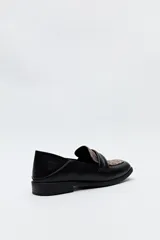 Mocasín negro de cuero sintético con punta cuadrada y detalle de bordado a tono en la capellada. Taco de 2,5cm.