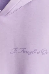 Buzo canguro lila con capucha, corte holgado, hombros caídos, bolsillo delantero y puños y bajo acanalados. Estampado con la frase "Paris, France" y "Le Triangle d'Or".