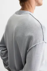 Sweater negro de algodón con cuello redondo y mangas largas. Tiene un acabado lavado con efecto desgastado y rib en cuello, puños y bajo.
