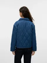 Campera de denim azul con cuello tipo spread collar, bolsillos delanteros, forro completo y acolchado ligero. Confeccionada en tejido sastrero twill con 80% algodón y 20% poliéster, presenta un acabado enzyme wash para una textura más suave y un efecto stonewash que aporta un look desgastado y vintage.