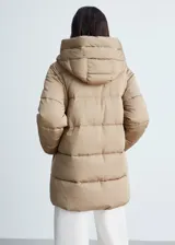 Campera puffer color beige con capucha, cierre frontal con cremallera y bolsillos laterales.