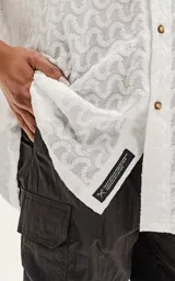 Camisa blanca con estampado de abanicos en tonos celeste, azul y amarillo.