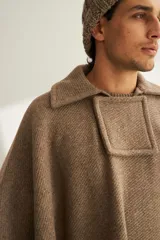 Poncho unisex de lana color marrón con cuello alto y broche a presión. Diseño exclusivo de Don Baez, hecho en Uruguay.