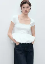 Camiseta blanca con cuello cuadrado, mangas cortas y corte crop con peplum. Jeans de tiro alto color azul oscuro.