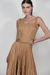 Corset color tostado confeccionado en nylon técnico despuntado, con diseño geométrico de costuras marcadas y paneles en zigzag. Presenta recortes laterales y breteles fruncidos.