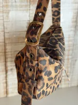 Bolso de hombro con estampado animal print, correa regulable, interior forrado y cierre superior. Incluye llavero, bolsillos internos.