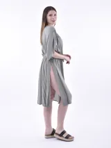 Vestido corto color gris claro, con escote en V, mangas cortas amplias y lazo ajustable en la cintura.