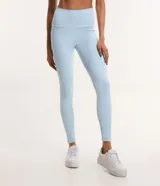 Conjunto deportivo celeste compuesto por un top con tirantes finos y calzas largas con cintura alta y recortes en las rodillas.