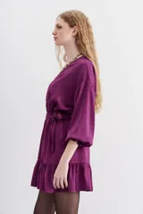 Vestido corto color violeta, de escote cruzado con volados, mangas largas abullonadas y cintura elastizada. Confeccionado en jacquard con corazones.