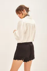 Short negro de satén viscosa con cintura elastizada y detalle de bordado calado en el ruedo.