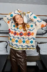 Sweater de lana tejido a mano en Uruguay, de calce holgado, con cuello a la base y puños ajustados. Diseño con motivos geométricos en colores azul, amarillo, rojo y blanco.