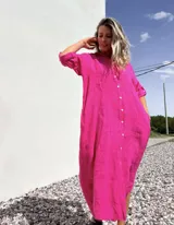 Vestido camisero midi de lino color fucsia, con cuello camisero, mangas 3/4 y cierre frontal con botones.