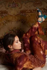 Pantalón de tiro medio con elástico en la cintura y corte acampanado. Diseño con estampado abstracto en tonos marrones, rojizos y amarillos, con textura tipo piel de reptil.