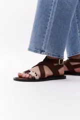 Sandalias negras con tiras cruzadas de cuero y pelo vacuno con estampado animal print.