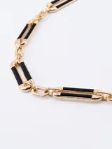 Collar dorado con eslabones rectangulares negros.