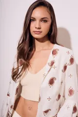 Blusa blanca con estampado de cachemir en color marrón y bordado floral en el ruedo y mangas acampanadas.