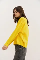 Sweater amarillo de punto con cuello redondo y mangas largas.