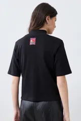 Remera de media polera color crudo, de manga corta y corte recto.