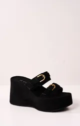 Sandalias negras de plataforma con dos tiras anchas de gamuza y hebillas doradas.