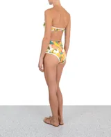Calzón de bikini de tiro alto con estampado floral en tonos naranja, verde, amarillo y celeste. Tiene cintura alta con cobertura total y ribete blanco.