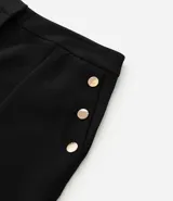 Bermuda de crepé color rojo, con pliegues frontales y botones decorativos en los bolsillos laterales.