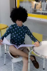 Remera de manga larga verde oscuro con estampado de lunares violetas.