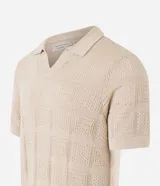 Remera polo de manga corta color beige, con cuello inglés y textura patchwork en cuadrados.