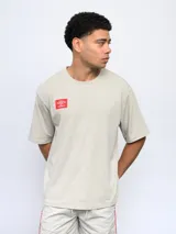 Remera color arena de corte holgado, con cuello redondo y logo de Umbro estampado en el pecho.