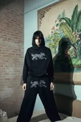 Pantalón negro de felpa de algodón, corte oversize, con doble cintura simulando bóxer y estampa de alta calidad.