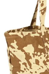 Bolso shopper con estampado animal print en tonos beige y marrón. Tiene doble asa de hombro y cierre superior.
