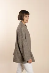 Capa marrón con bolsillos, mangas amplias y pinzas en la delantera. Terminaciones interiores envivadas. Confeccionada en lana fina sin teñir, diseñada exclusivamente por Don Baez.