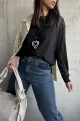 Remera negra de manga larga, con un hombro de tela de algodón y el otro de encaje.