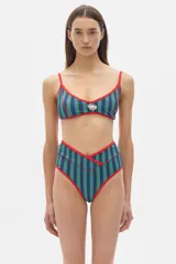 Top de bikini negro con textura, breteles finos y contorno en color crema.