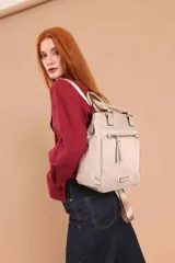 Mochila color vainilla con diseño moderno y funcional. Cuenta con un amplio compartimento principal, un bolsillo frontal con cierre y dos bolsillos laterales. Incluye una correa ajustable para mayor comodidad.