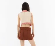 Falda corta confeccionada en gabardina con cierre frontal metálico, de mezcla de algodón y elastano para mayor comodidad.