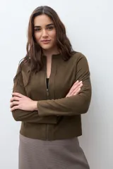 Chaqueta corta de simil gamuza color verde oliva, con cuello redondo y cierre frontal completo.