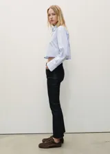 Pantalón de jeans negro con efecto encerado, tiro medio, corte bootcut y largo cropped.