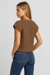 Musculosa color crema de acrílico con punto canalé, corte holgado y escote en V profundo.