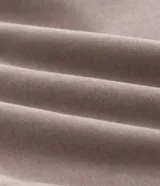 Pantalón baggy color beige, confeccionado en algodón con felpa. Presenta cintura elástica con cordón ajustable, bolsillos delanteros y un bolsillo trasero. El bajo es ajustable con elástico.