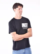 Remera blanca de corte recto con estampa fotográfica de edificios en la parte frontal.