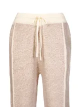 Pantalón de jogging tejido en tonos beige y crema, con cintura elástica con cordón ajustable y corte recto.