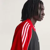 Campera Adidas Originals de corte holgado, con cuerpo en tejido de malla negro y mangas en color rojo con las icónicas tres tiras blancas. Presenta cierre frontal completo, cuello tipo bomber y logo del trébol bordado en el pecho.