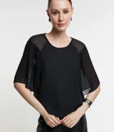 Blusa de gasa negra con cuello redondo y mangas cortas amplias texturizadas con transparencias.