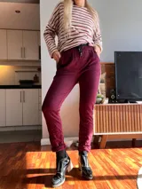 Pantalón bordó de corte recto, con bolsillos laterales y una franja dorada con estampado animal print en los laterales.