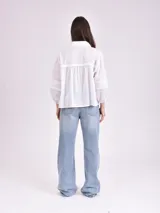Blusa color beige con cuello mao, escote en V y mangas 3/4 con elástico en los puños.
