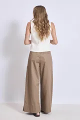 Pantalón palazzo color marrón claro, de tiro alto, con pinzas y bolsillos laterales.