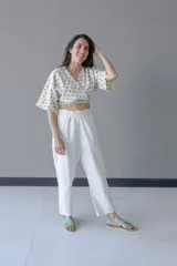 Top cruzado escotado de tusor de algodón con estampado de lunares verdes, cintura elastizada y manga corta holgada.