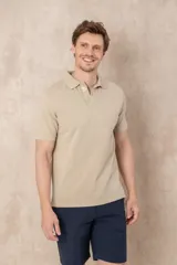 Remera tipo polo color beige, de manga corta y corte clásico. Tiene cuello con botones y está confeccionada en algodón.