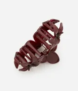 Pinza para el pelo color borgoña con forma de tres flores juntas. Accesorio de plástico y metal.