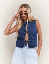 Chaleco de jean azul sin mangas con lazos en el frente.